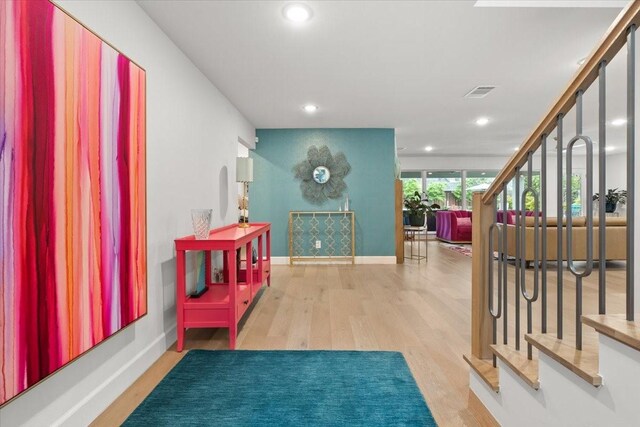 corridor featuring visible vents, wood finished floors, baseboards, stairway, and recessed lighting