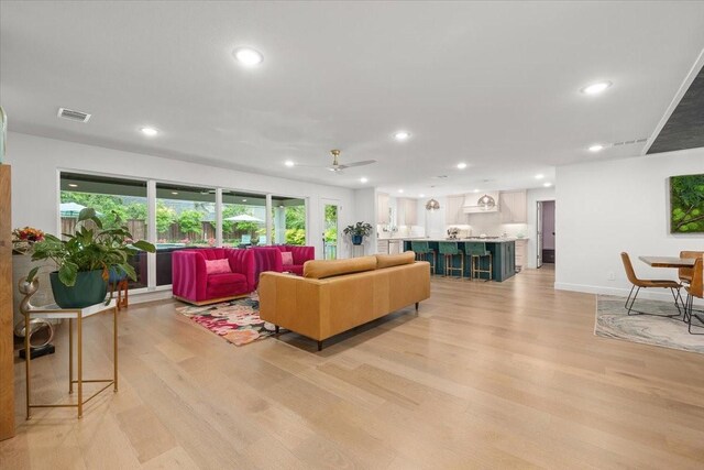 living area featuring recessed lighting, light wood-style flooring, a healthy amount of sunlight, and visible vents
