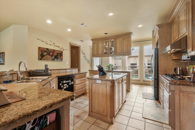 kitchen with visible vents, black appliances, under cabinet range hood, recessed lighting, and an island with sink