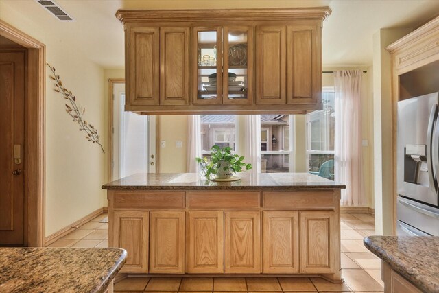 kitchen featuring a sink, under cabinet range hood, a large island with sink, and visible vents