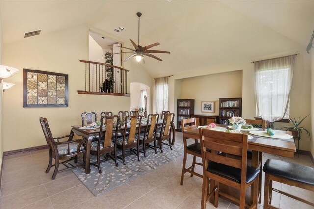 dining room featuring visible vents, baseboards, high vaulted ceiling, a ceiling fan, and light tile patterned floors