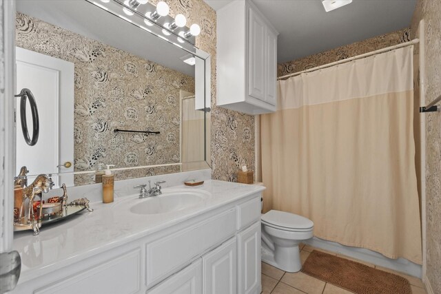 bedroom with a ceiling fan, wallpapered walls, and wood finished floors
