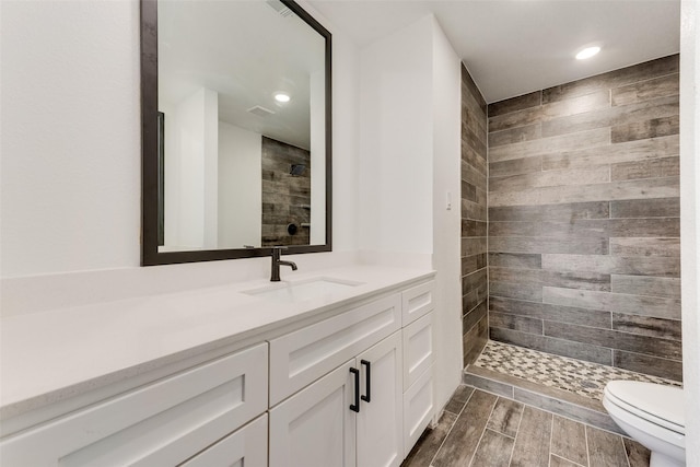 1130 Amsden Cir, Denison, TX 75020 - bathroom featuring wood tiled floor, vanity, toilet, recessed lighting, and tiled shower