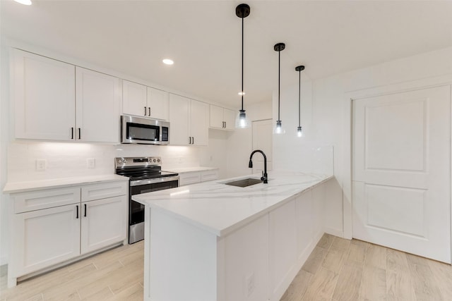 1130 Amsden Cir, Denison, TX 75020 - kitchen featuring a peninsula, white cabinets, tasteful backsplash, a sink, and stainless steel appliances
