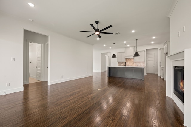 526 Windchase Dr, Haslet, TX 76052 - unfurnished living room with a ceiling fan, dark wood-type flooring, a glass covered fireplace, recessed lighting, and baseboards