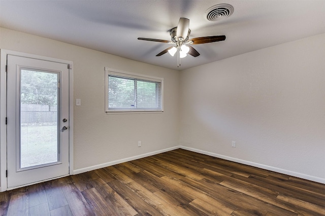 interior space featuring baseboards, ceiling fan, dark wood-style flooring, and visible vents