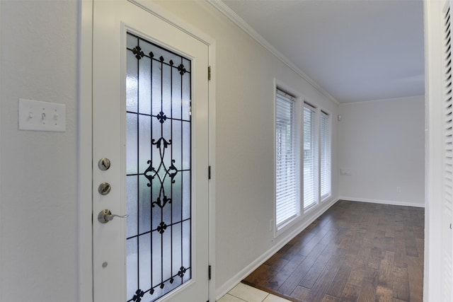foyer featuring baseboards, ornamental molding, and wood finished floors