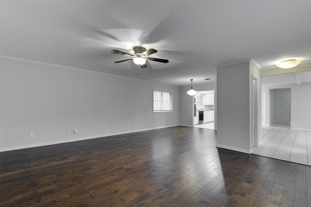 unfurnished living room with crown molding, a ceiling fan, baseboards, and dark wood finished floors