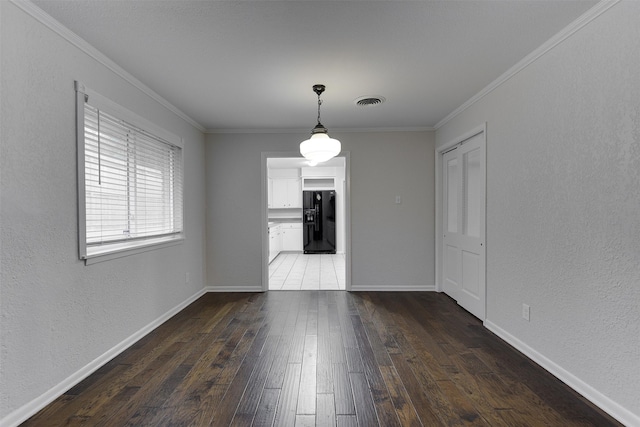 unfurnished dining area featuring crown molding, baseboards, and hardwood / wood-style floors