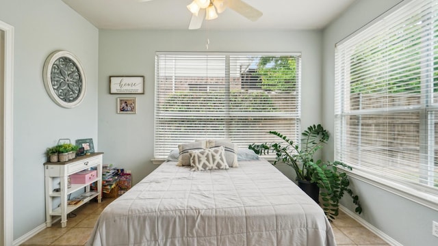 bedroom featuring tile patterned flooring, a ceiling fan, baseboards, and multiple windows