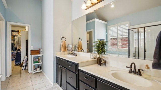 bathroom with a sink, tile patterned floors, a shower stall, and double vanity