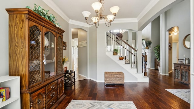 entryway featuring crown molding, arched walkways, wood finished floors, an inviting chandelier, and stairs