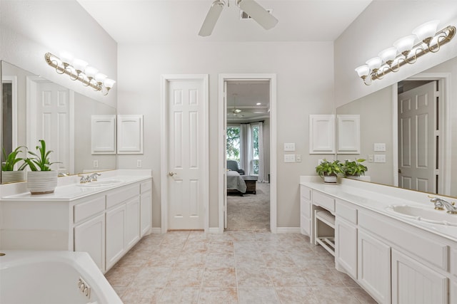 bathroom featuring ceiling fan, two vanities, and a sink