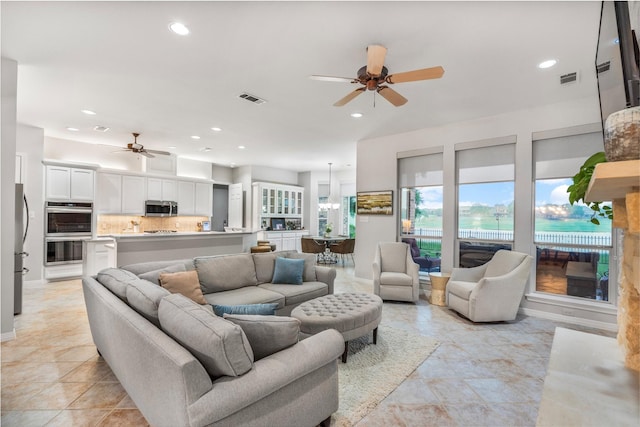living area featuring recessed lighting, visible vents, and ceiling fan with notable chandelier