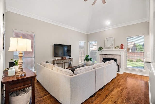 living room with ceiling fan, dark wood-style flooring, a tiled fireplace, high vaulted ceiling, and ornamental molding
