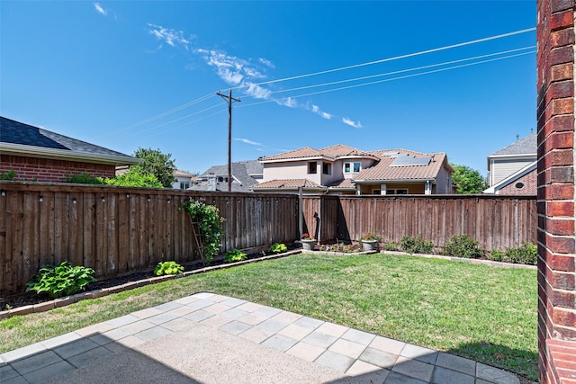 view of yard featuring a fenced backyard, a patio area, and a residential view