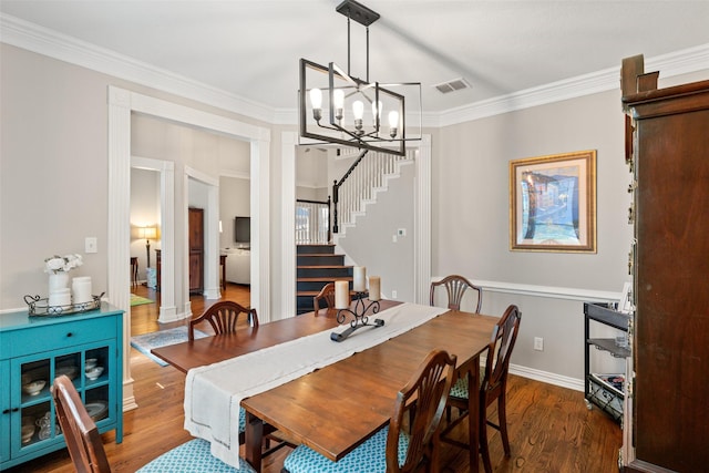 dining space with visible vents, crown molding, stairway, a chandelier, and dark wood-type flooring