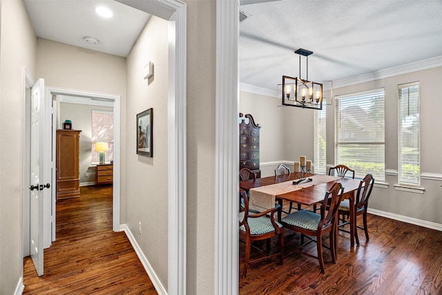 dining area featuring baseboards, ornamental molding, dark wood-style flooring, and a chandelier