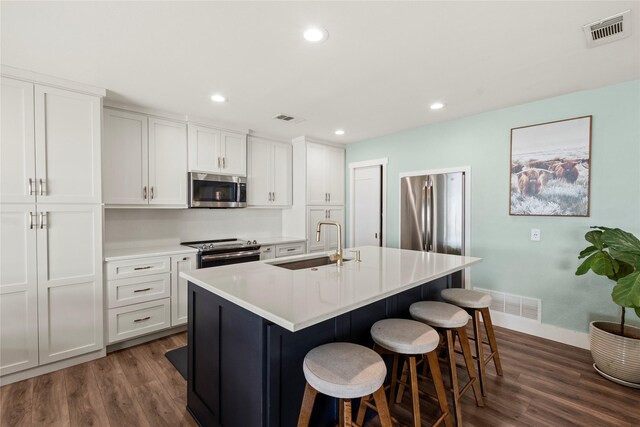 kitchen with a sink, baseboards, stainless steel appliances, and dark wood-style flooring