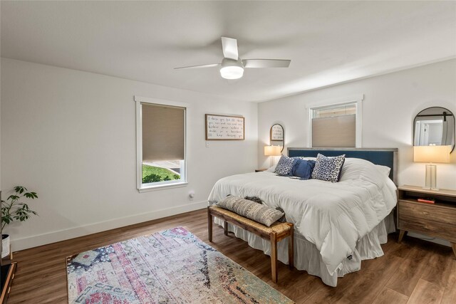 bedroom with baseboards, ceiling fan, wood finished floors, and multiple windows