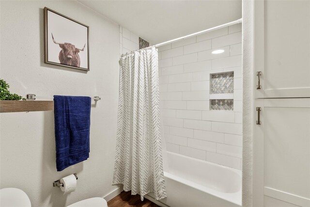 full bathroom featuring baseboards, shower / bath combo with shower curtain, toilet, and wood finished floors