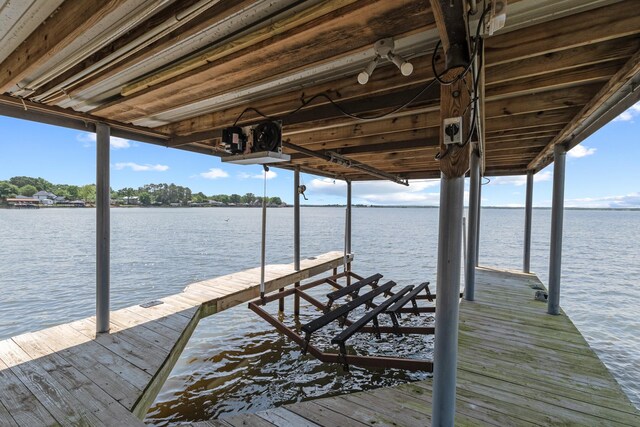 dock area with boat lift and a water view