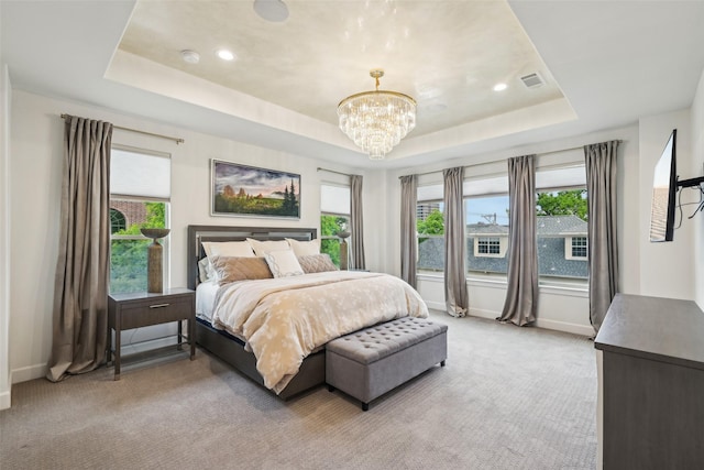 bedroom featuring a raised ceiling, multiple windows, and visible vents