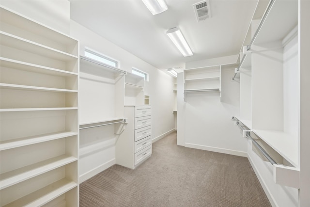 walk in closet with light colored carpet and visible vents
