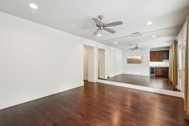 unfurnished living room with beverage cooler, a ceiling fan, baseboards, and recessed lighting