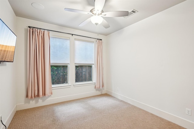carpeted empty room featuring visible vents, baseboards, and ceiling fan