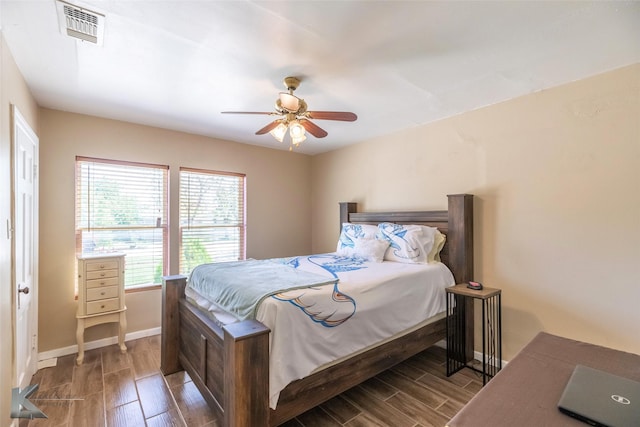 bedroom with baseboards, ceiling fan, wood finish floors, and visible vents