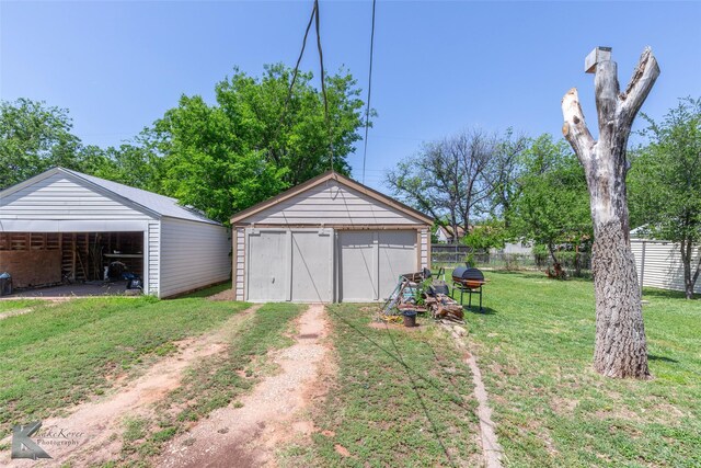 detached garage featuring fence