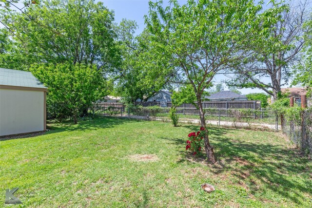 view of yard with a fenced backyard and an outbuilding