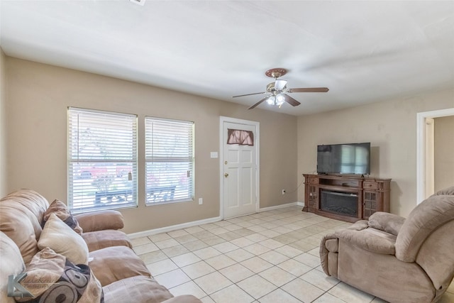 living room featuring baseboards, ceiling fan, light tile patterned floors, and a fireplace