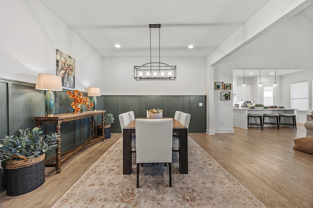 4771 Sasha Way, Caddo Mills, TX 75135 - dining area with a wainscoted wall, a chandelier, wood finished floors, and a decorative wall