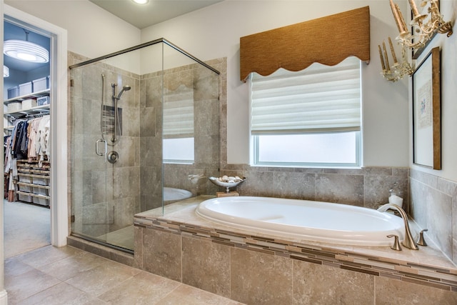 full bath featuring a walk in closet, a garden tub, and a stall shower