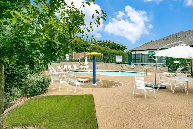 pool with fence and a patio