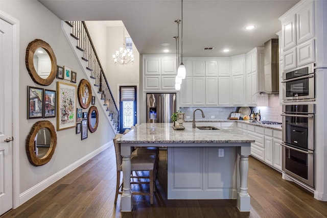 kitchen featuring a sink, appliances with stainless steel finishes, baseboards, and dark wood-style flooring
