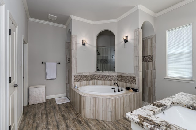full bath with a sink, wood finished floors, ornamental molding, tiled shower, and a bath