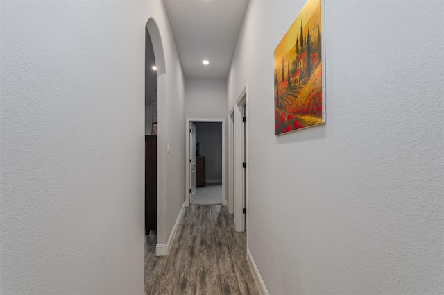 hall with arched walkways, baseboards, recessed lighting, and wood finished floors