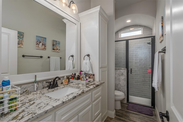 full bathroom with toilet, a shower stall, wood finished floors, and vanity
