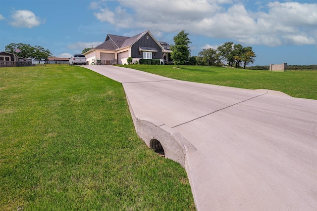 view of front of home with board and batten siding, an attached garage, driveway, and a front lawn