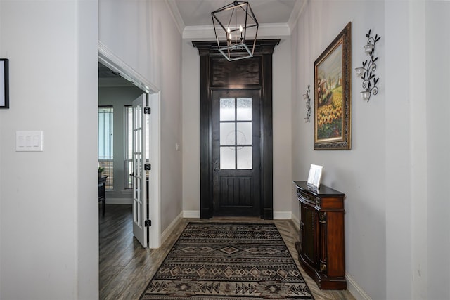 entryway with crown molding, baseboards, dark wood finished floors, and a notable chandelier