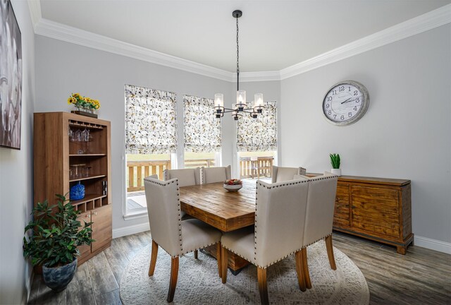 dining room with crown molding, baseboards, wood finished floors, and a chandelier
