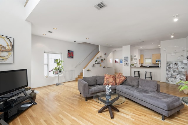 4030 Travis St Unit A, Dallas, TX 75204 - living room with wood finished floors, stairs, recessed lighting, and radiator heating unit