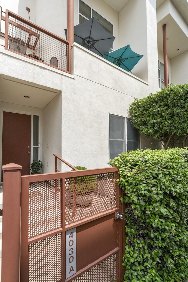 view of side of property with stucco siding and a balcony