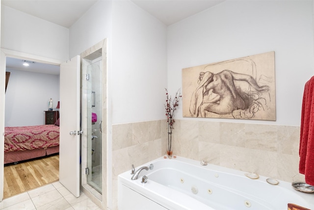 full bathroom featuring tile patterned floors, a whirlpool tub, a stall shower, and connected bathroom