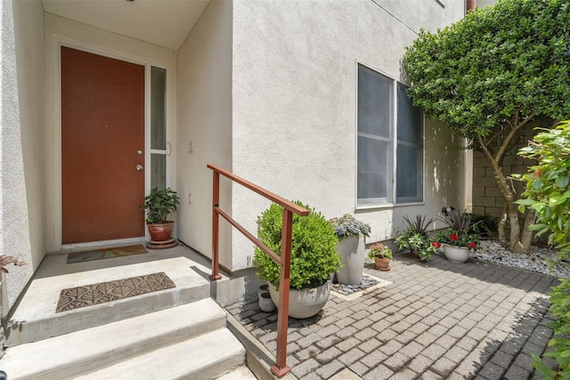 property entrance featuring a patio and stucco siding