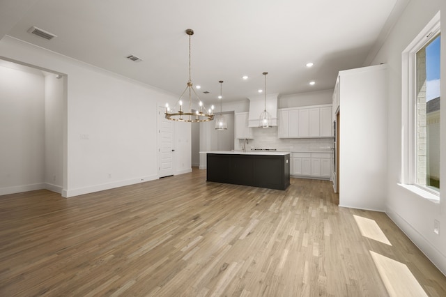 201 Kingfisher Ct, Aledo, TX 76008 - kitchen with a chandelier, decorative backsplash, open floor plan, white cabinets, and light wood finished floors