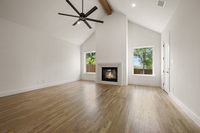 201 Kingfisher Ct, Aledo, TX 76008 - unfurnished living room with beam ceiling, wood finished floors, high vaulted ceiling, ceiling fan, and a glass covered fireplace